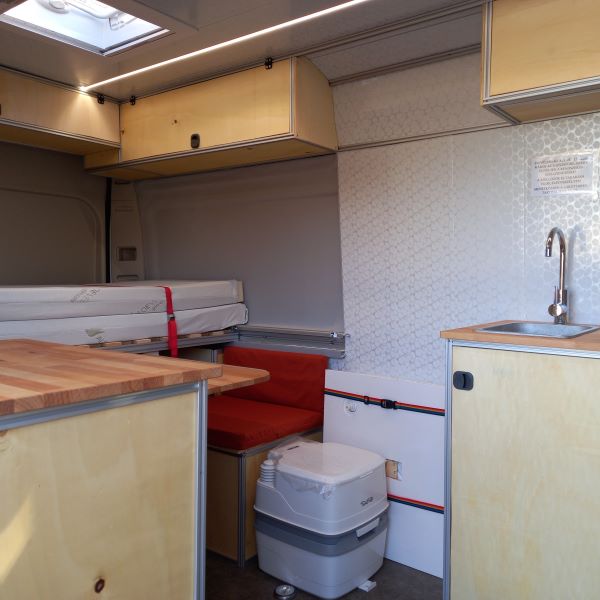 lakóautónk belseje, lenyitható zuhanytó, alumínium vázas bútorok